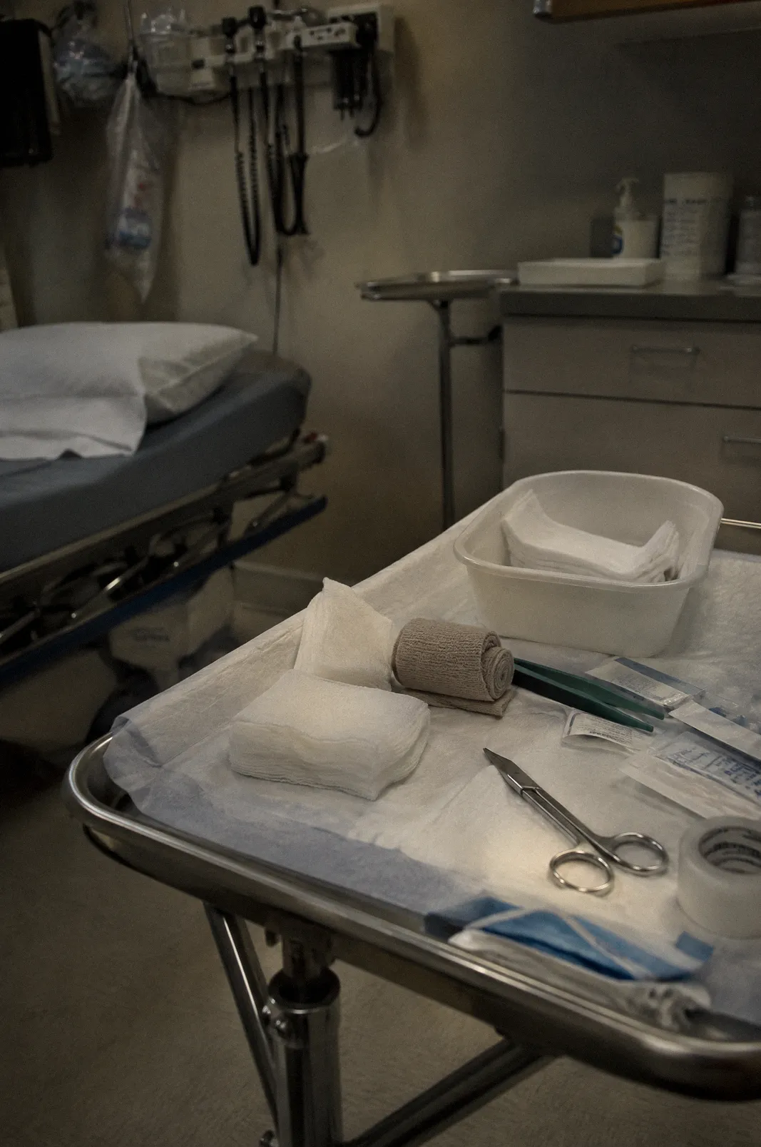 Sterile gauze and bandage supplies laid out on a clinic tray, clinical light, nothing graphic