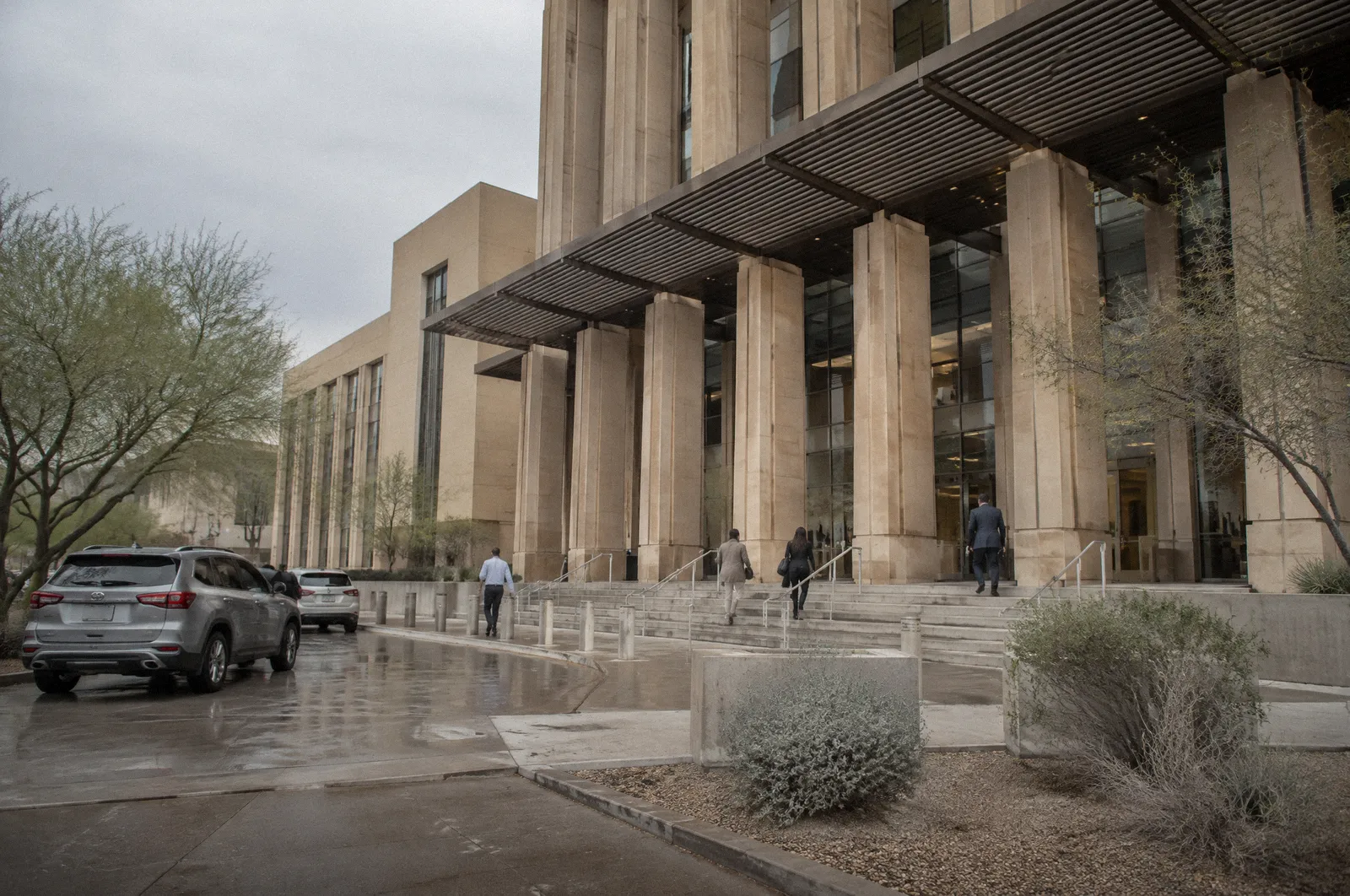 A modern desert-toned courthouse exterior with tall columns and shade structures, midday, no readable lettering