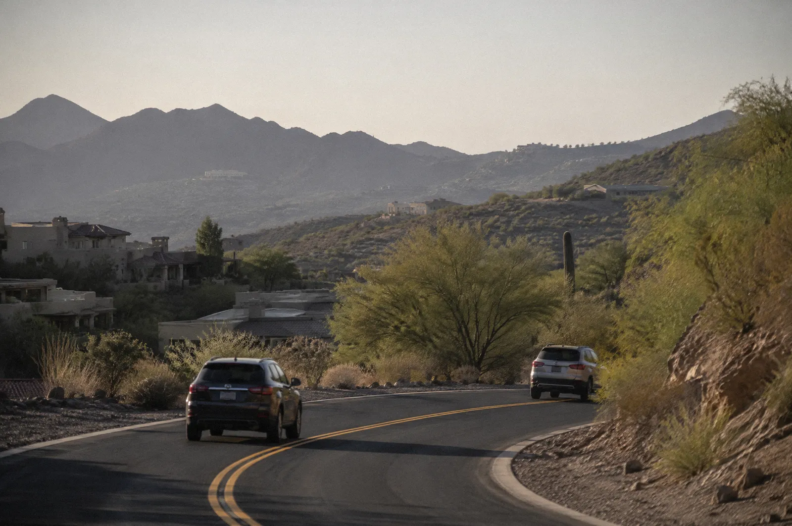A winding road through Fountain Hills with desert hills and scattered homes, afternoon