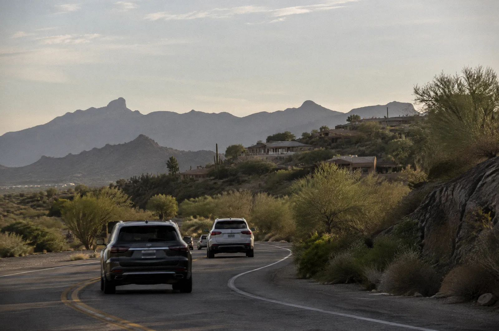 A winding road through Fountain Hills with desert hills and scattered homes, afternoon