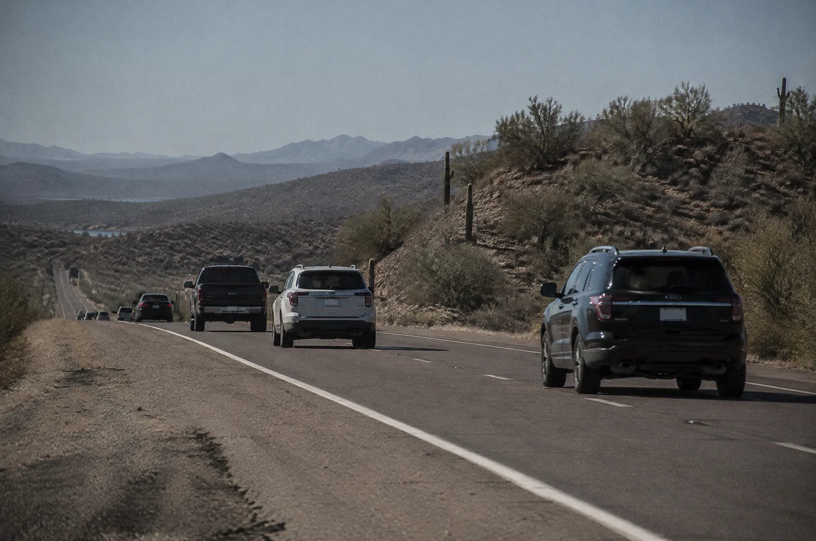 Lake Pleasant Parkway area in Peoria, desert hills, a long straight road with light traffic