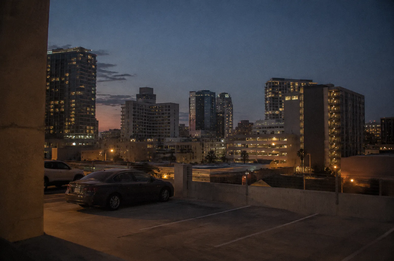 Downtown Phoenix skyline at blue hour from a parking structure, mid-rise towers, no readable building names