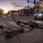 A tipped-over rental electric scooter near a Tempe crosswalk, illustrating e scooter and e bike injuries in Tempe A tipped-over rental electric scooter near a Tempe crosswalk, illustrating e scooter and e bike injuries in Tempe